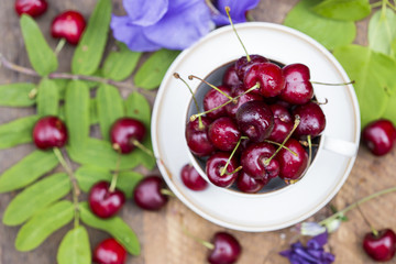 Cherries in the cup on wooden table