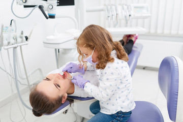 Little girl examining dentist in cabinet