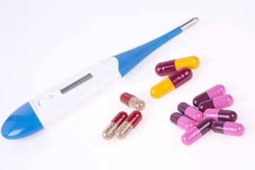 Health care concept with digital thermometer and pills