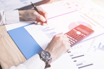 Businessman are working on a table  with graph documents and sunset light background.