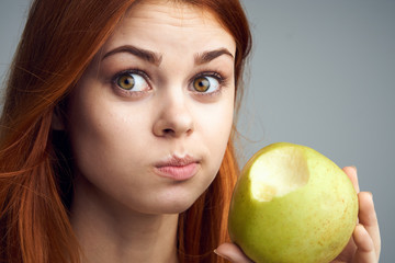 Diet, vitamins A, B, C woman eating an apple, a woman took a bite of an apple and acer portrait background