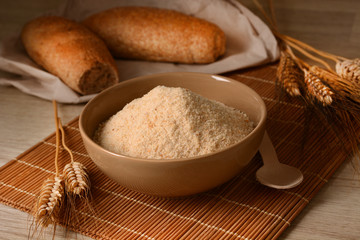 Bread crumbs in the bowl on the wooden table