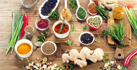 Various spices and herbs on rustic wooden background.