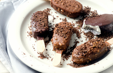 Chocolate ice cream popsicles on white plate