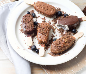 Chocolate ice cream popsicles on white plate