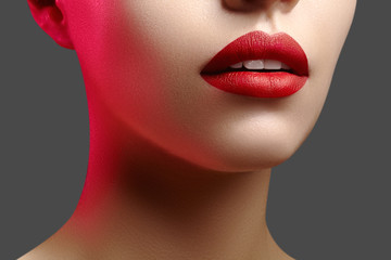 Obraz premium Cosmetics, makeup. Bright lipstick on lips. Closeup of beautiful female mouth with red lip makeup. Clean skin model