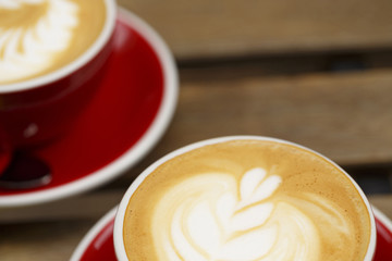 Coffee in red cup on wooden table, Colorful photo of coffee with defocused table in the background, Selective focus with shallow depth of field