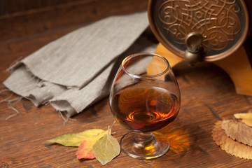 Glass of cognac on old wooden table