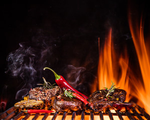 Beef steaks on the grill with flames