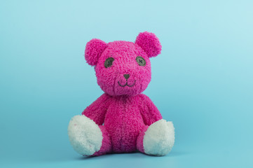 pink bear doll on blue background