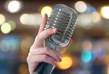 Female hand with vintage  microphone on white background