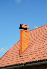 Red Metal Roof Tiles with brick chimney.  Roofing Construction, roof repair.