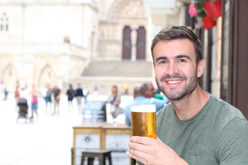 Happy man holding his cold refreshing beer