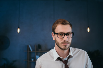 portrait of caucasian businessman in glasses looking at camera at office