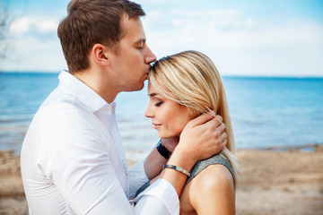 Fototapeta na wymiar Romantic young couple standing head to head at beach