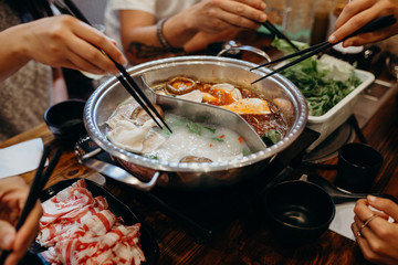 Korean hot pot meal. Hands taking food with chopsticks. - 160818286