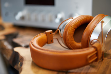 Vintage Headphones lie on a wooden table. Background amplifier hifi