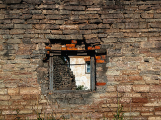 Old brick wall of a ruined building with a window