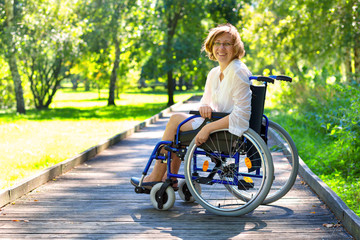 Fototapeta na wymiar young adult woman on wheelchair in the park