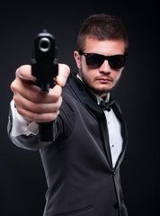 Violent gangster aiming with gun at you