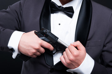 Mafia gangster in suit with gun in closeup