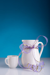 white jug and a mug with violette ribbon