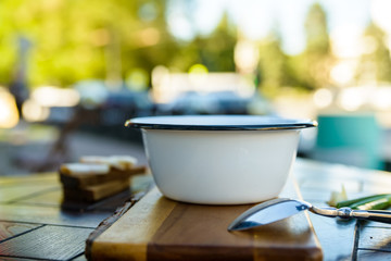 Metal bowl with soup on wooden table outdoors