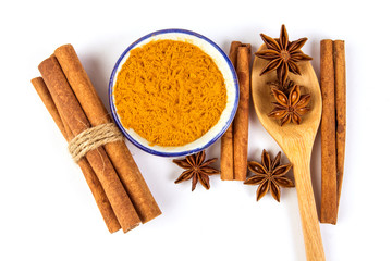 Close up the brown cinnamon stick and powder with star anise spice in wooden spoon isolated on white background