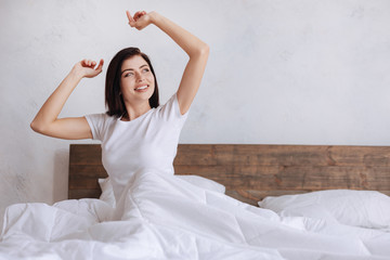 Excited woman waking up with arms outstretched