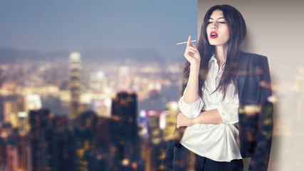 Woman smoking on balcony in night city