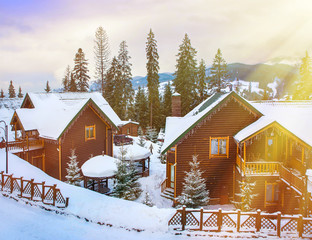 Christmas winter landscape, old wooden house, surrounded by snow-capped fir trees