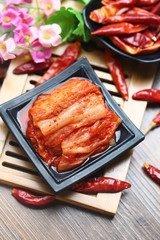 Korean kimchi in black plate on bamboo