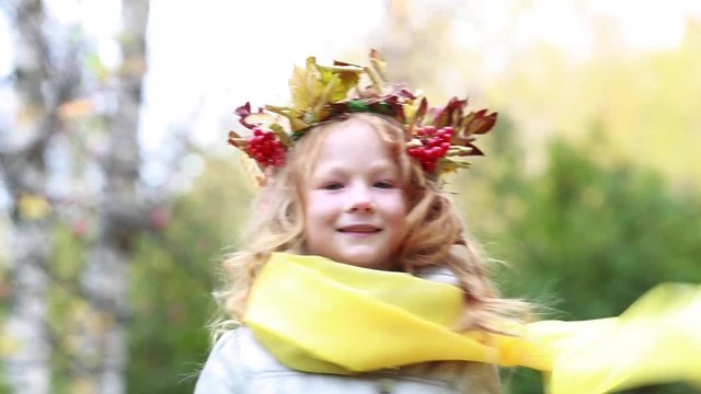 Red-haired girl with a wreath on her head in an autumn forest