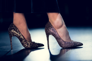 cropped view of glamour woman walking in shiny glitter high heels and long dress