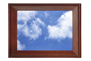 Old vintage wooden frame on a white background with the image of blue and clouds in it.