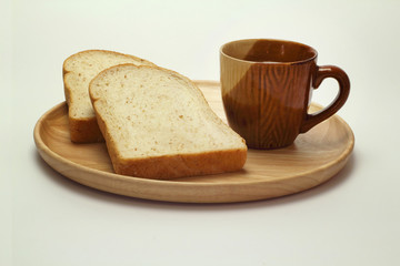 Wheat bread and cup of coffee on a white background