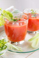 Two glasses of fresh tomato juice with thyme and celery.