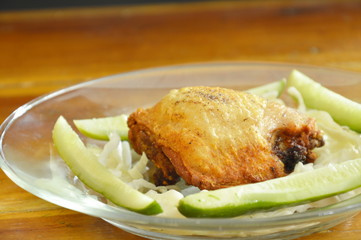 fried chicken thigh dressing salt and pepper with vegetable on plate
