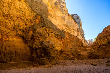 Inside a cove on the coast of Lagos, Portugal as the sunset fills it with warm evening light. 