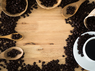 top view coffee cup and coffee beans in basket weave and wood spoon on wood table
