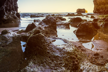 A view of the tide coming in from the rocky beach in Lagos, Portugal during sunset