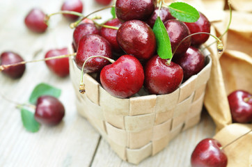 Basket of sweet fresh cherries on wooden background