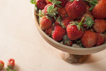 Fresh strawberries in wooden kitchenware, wooden background,