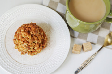 Coffee in a green mug and dessert from a shortbread in the form of a hill