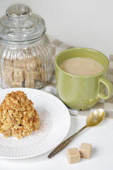 Coffee in a green mug and dessert from a shortbread in the form of a hill