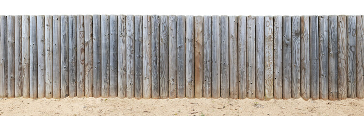 At top of the sandy hill there is a wooden fence from shot vertical pine logs.