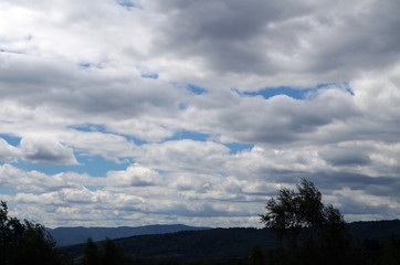 A view of the Carpathian mountains under the blue sky and white clouds