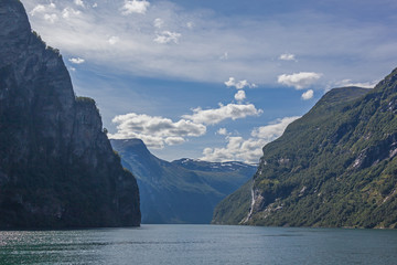 A magnificent view of the Norwegian fjord surrounded by majestic mountains with snowy peaks