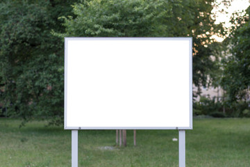 Blank ad space sign in front of trees