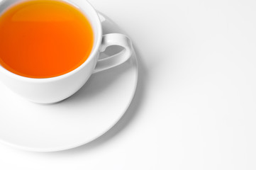 White cup with tea on gray background